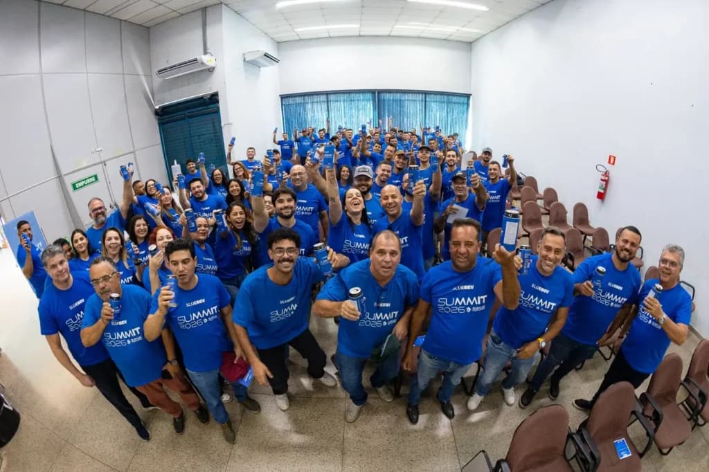 Equipe Blue Beverages reunida no Summit 2026, celebrando com latas de energético