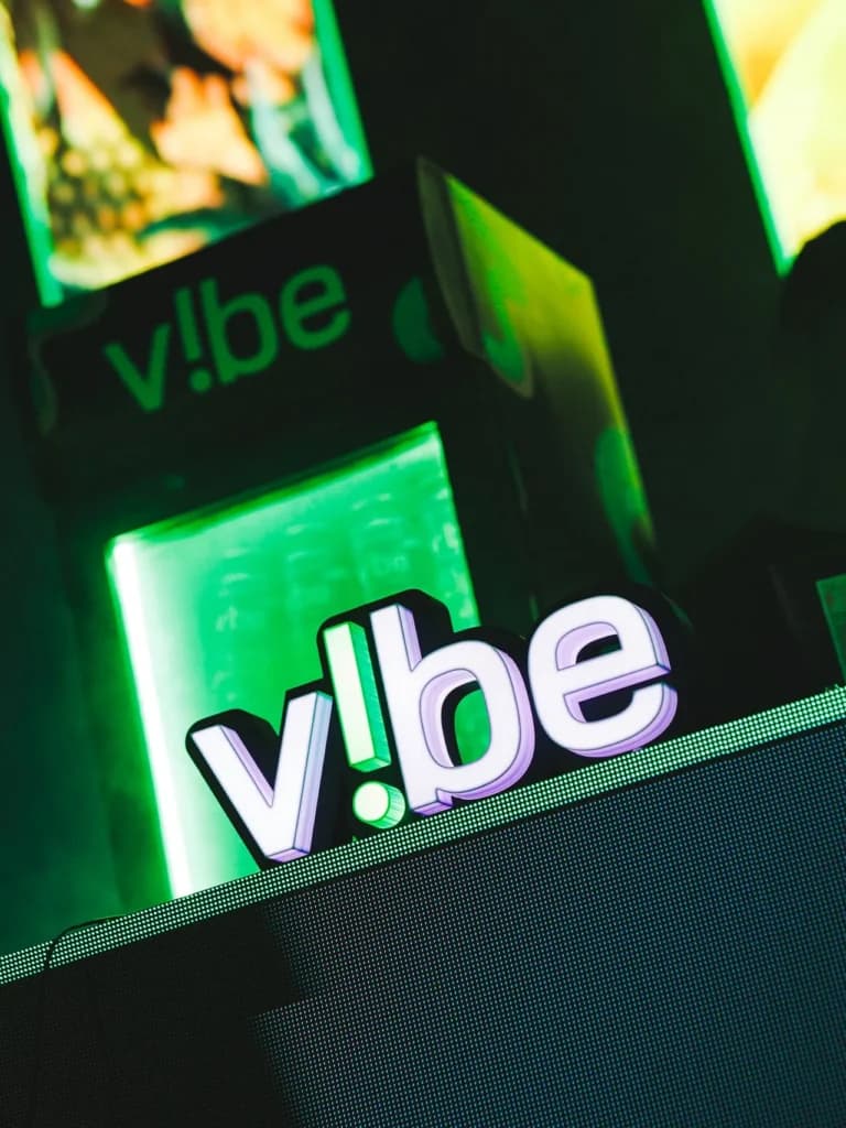 Identidade V!be iluminada em verde em uma ativação da marca